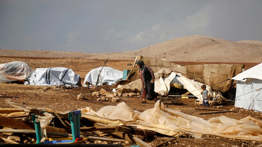 A Palestinian woman walks in Khirbet Humsah in Jordan Valley in the Israeli-occupied West Bank