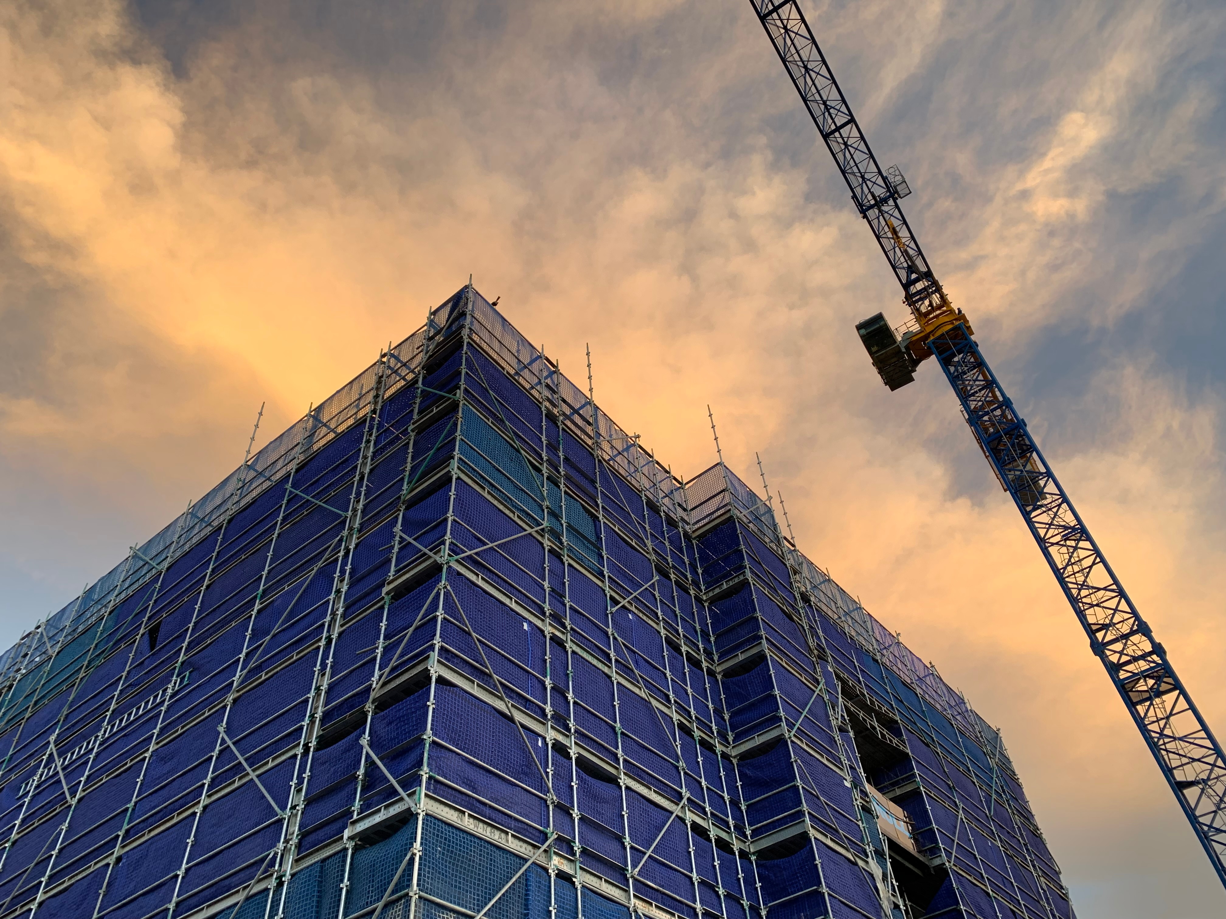 scaffolding around building next to crane