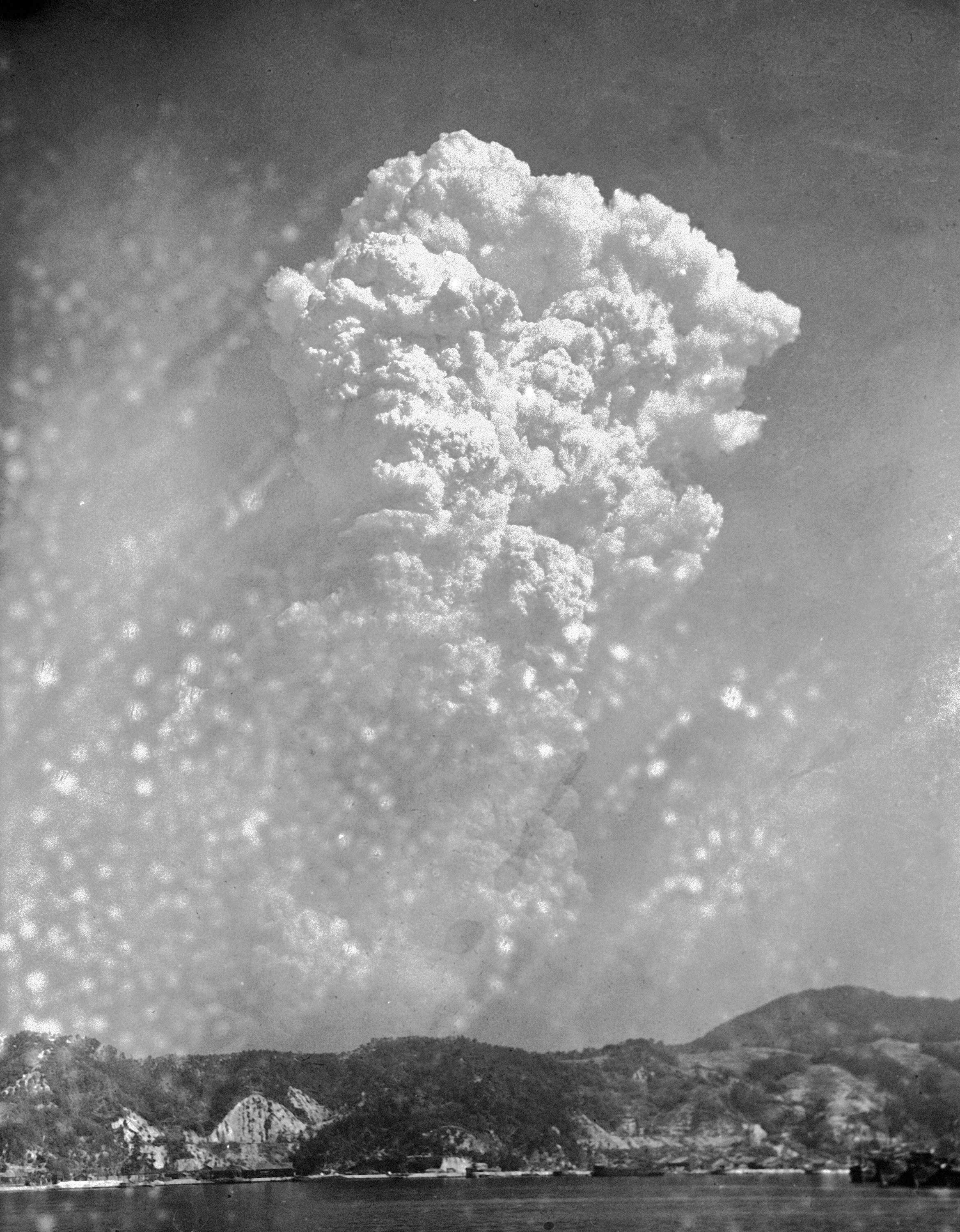 A massive cloud of smoke billows over a cove.