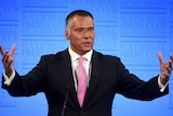Stan Grant gestures with both hands as he speaks at the National Press Club podium.