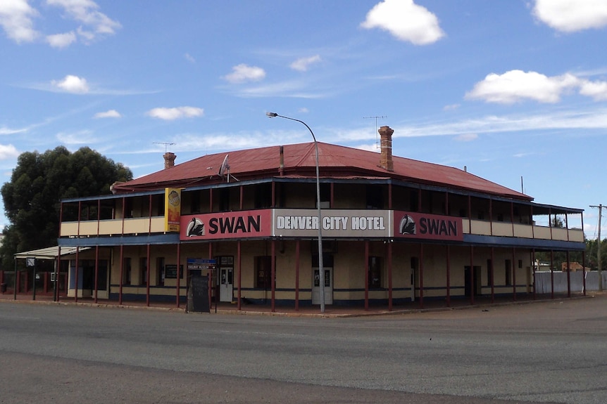 An old double-storey pub on a corner block in an outback town.