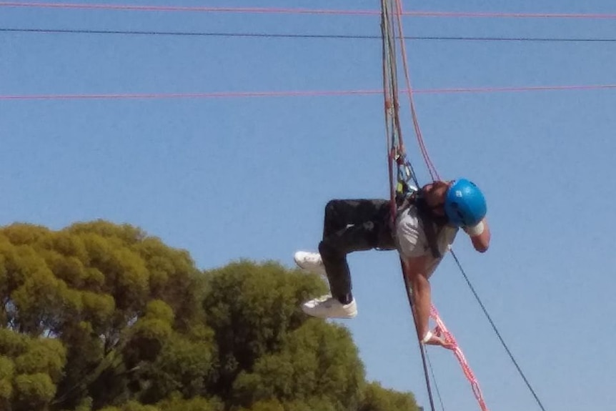 A man suspended from a rope on a flying fox