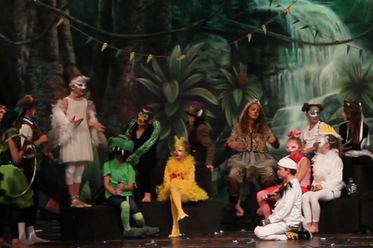 School performers on stage in animal costumes