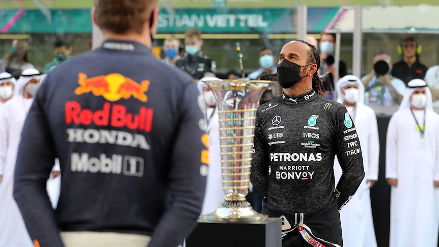 Lewis Hamilton and Max Verstappen stand with Championship trophy