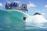A man surfs in the barrel of a large wave in a wave pool