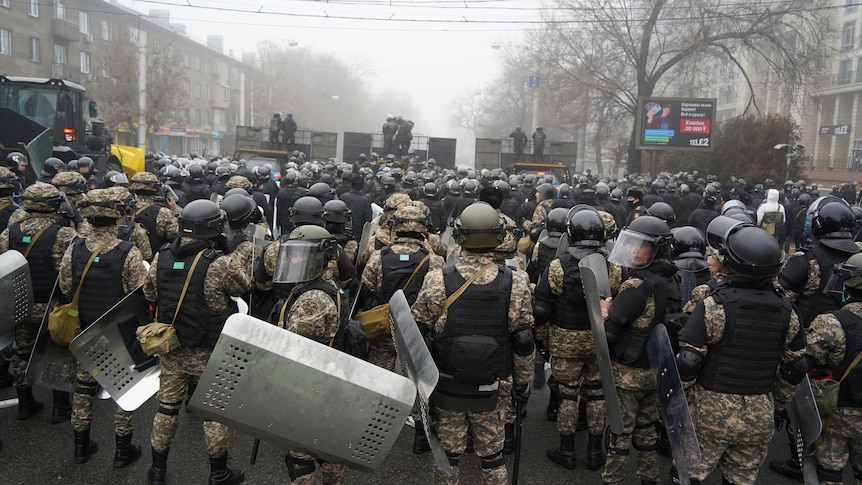 Riot police block a street to prevent demonstrators moving during a protest