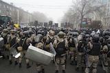 Riot police block a street to prevent demonstrators moving during a protest