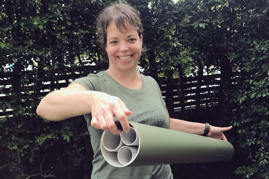 Dr Jodi Rowley with a frog hotel made from PVC pipes