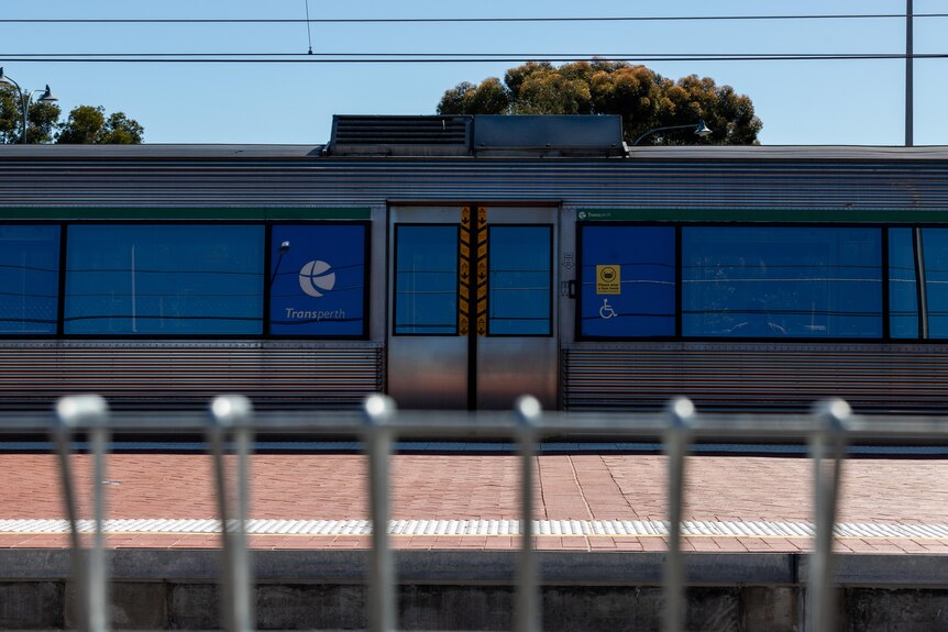 A train stopped at a station on a sunny day.