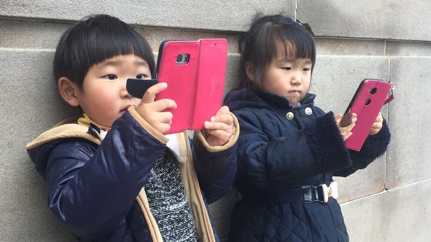 Children looking at mobile devices.