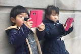 Children looking at mobile devices.