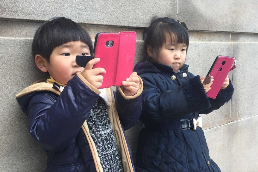 Children looking at mobile devices.