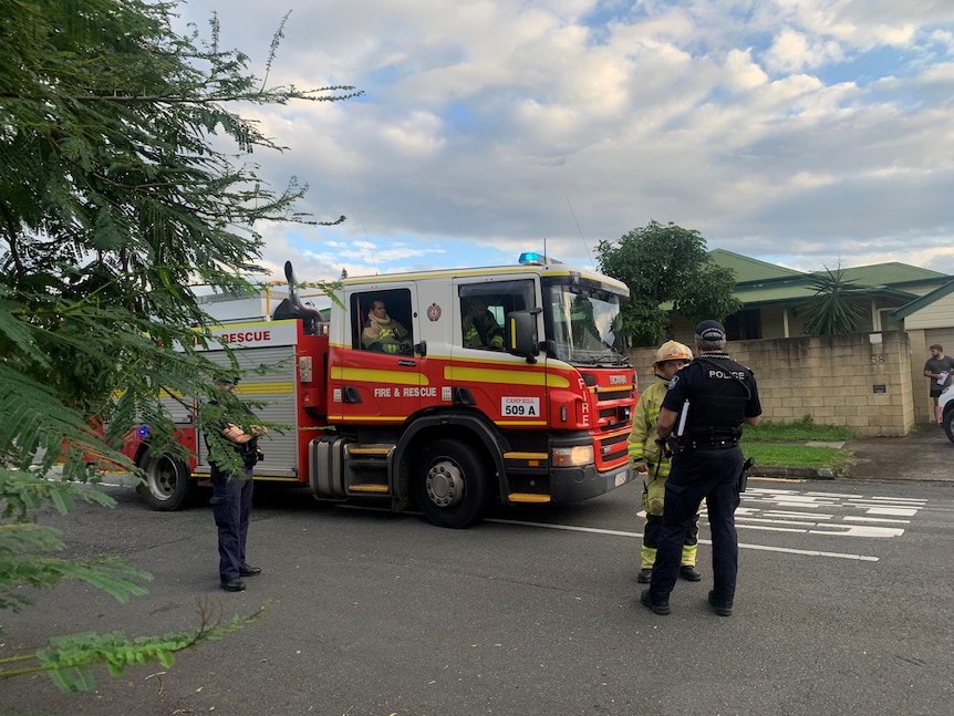 Firefighters stand around a truck. 