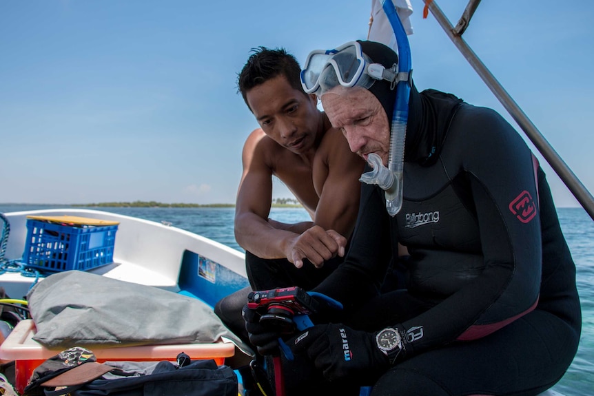 Scientists Dexter De La Cruz and Peter Harrison on a boat after inspecting a reef restoration site in the Philippines.