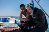 Scientists Dexter De La Cruz and Peter Harrison on a boat after inspecting a reef restoration site in the Philippines.