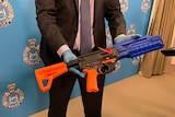 A DIY 3D Printed firearm seized by police being displayed at a press conference