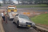 Car stuck in flood-damaged road in Yeppoon, north of Rockhampton in central Queensland on March 27, 2014