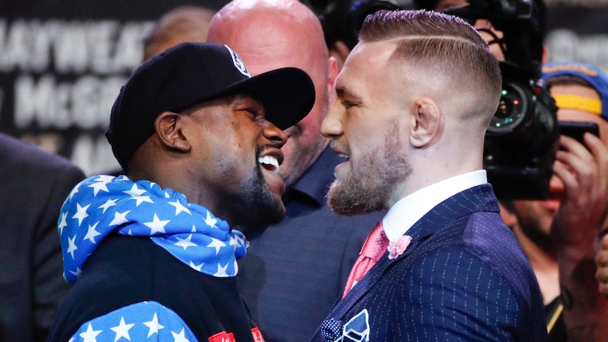 Floyd Mayweather and Conor McGregor stare each other down, nose to nose.