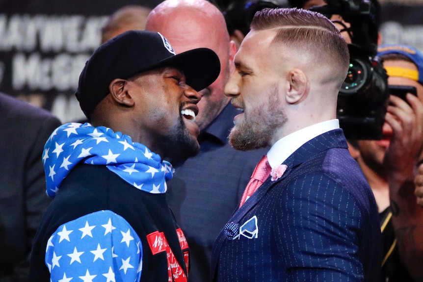 Floyd Mayweather and Conor McGregor stare each other down, nose to nose.
