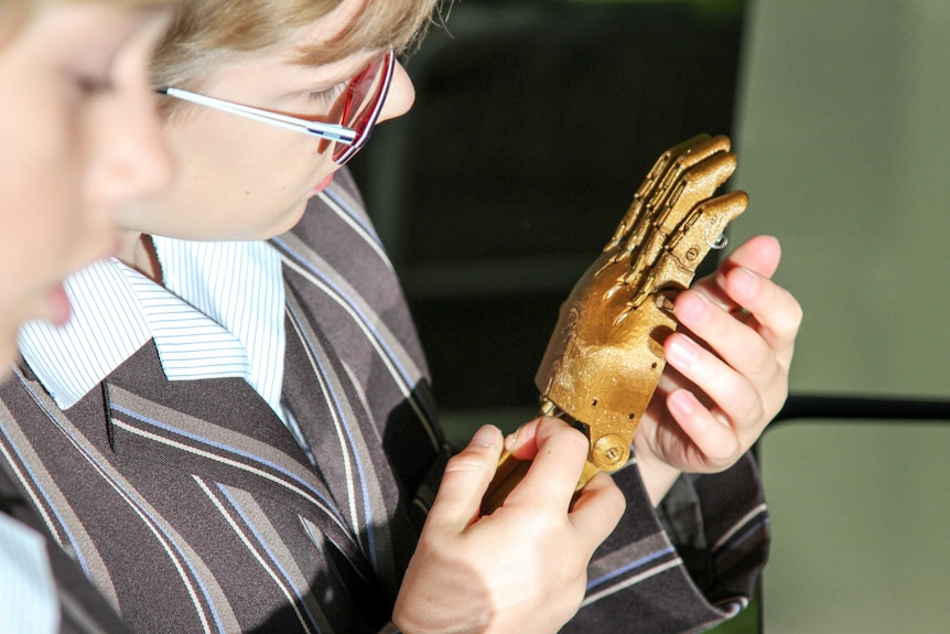 A student holding a prosthetic.