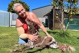 Sue Kole in her backyard hugging her dog
