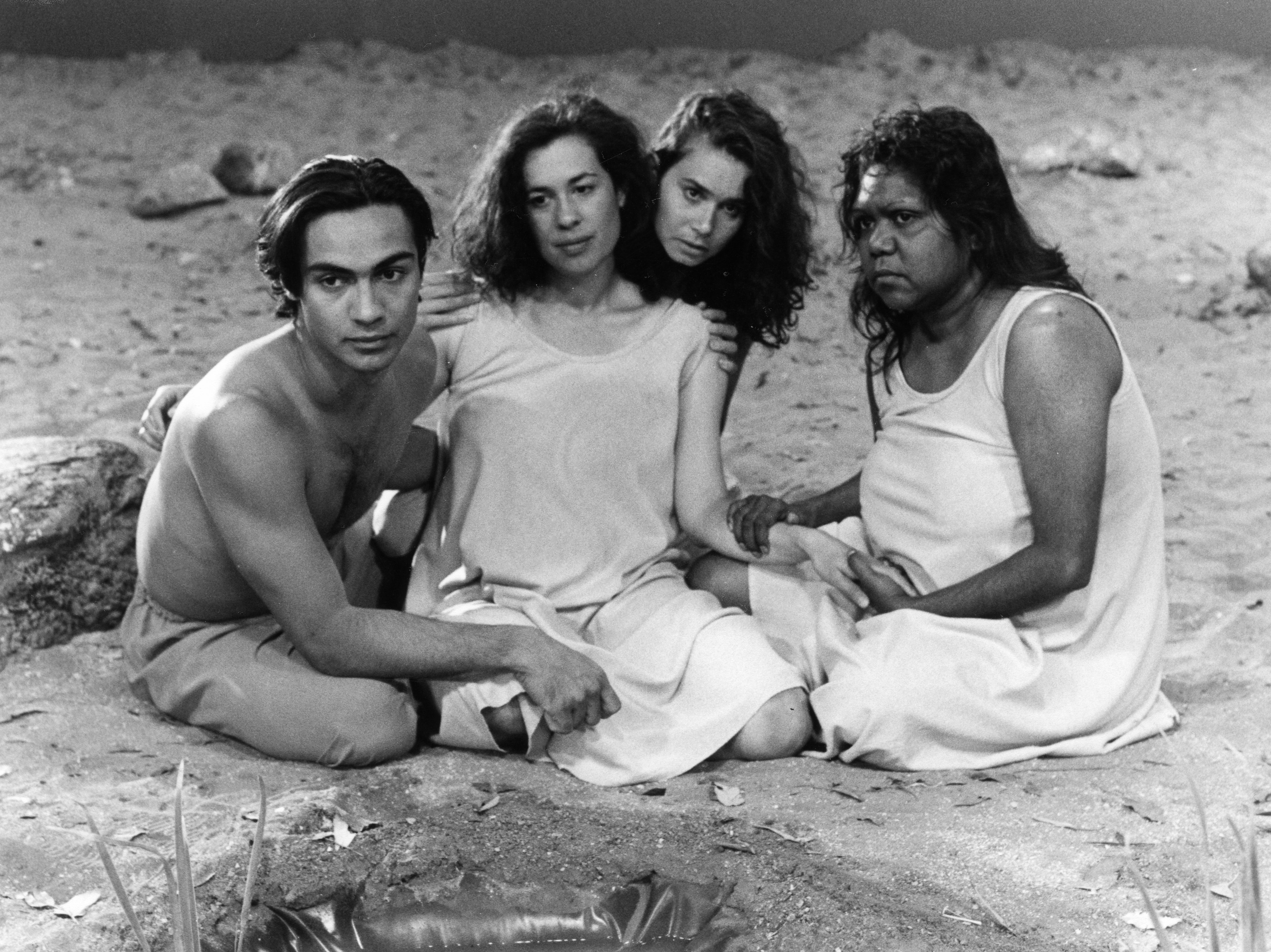 A group of people including Rhoda sat on the ground as part of a drama called poison. 