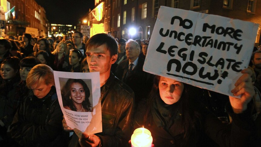 Protesters hold pictures of Savita Halappanavar as they demonstrate outside parliament in Dublin.