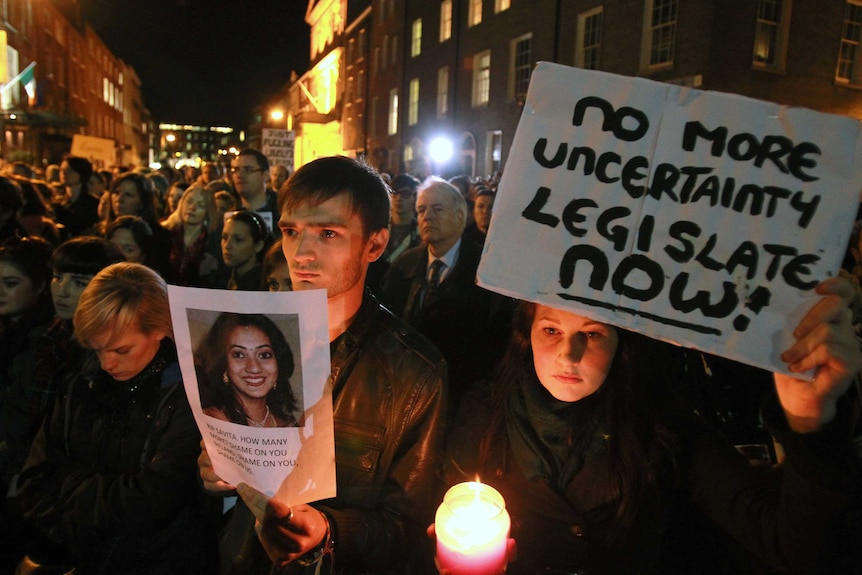 Protesters hold pictures of Savita Halappanavar as they demonstrate outside parliament in Dublin.