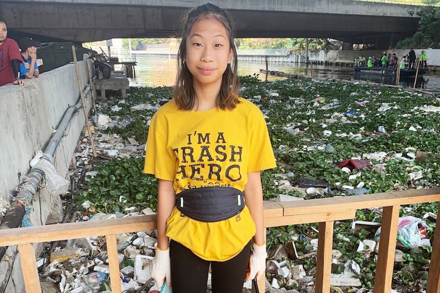 Lilly stands in front of a canal full of rubbish in Bangkok, Thailand, December 20, 2019.