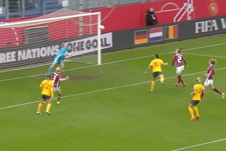 An Australian footballer heads home a goal against Germany.