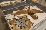 Two clocks and golden eagle sculptures made by Charles Falck in two boxes after they were delivered.