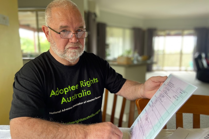 Man holding birth certificate and looking at camera