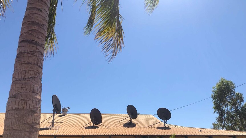 A house with four satellite dishes on the roof.