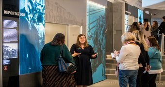 A historian explains a museum exhibit to guests.