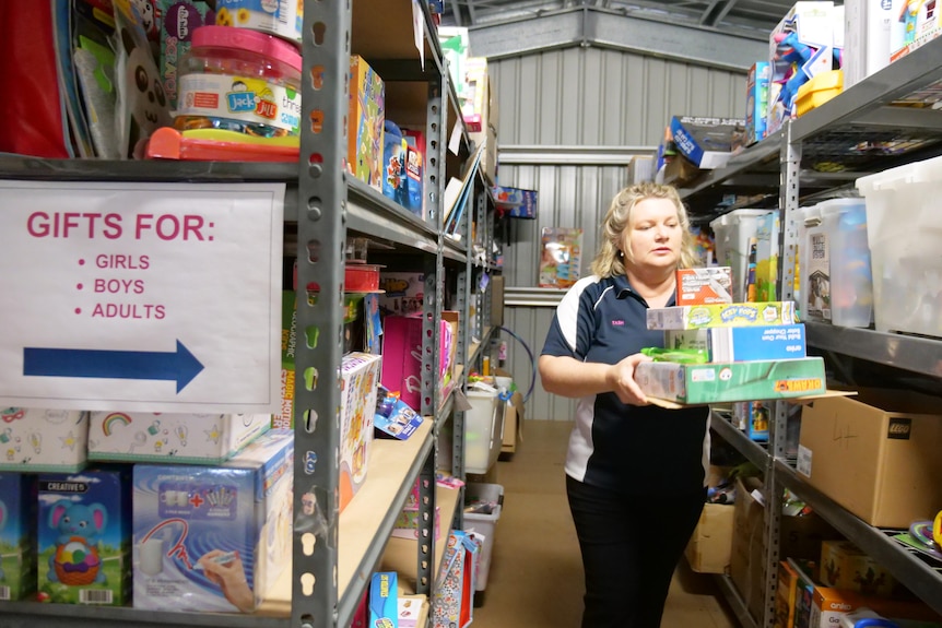 Natasha Johnston is walking out of an aisle with a handful of Christmas presents.