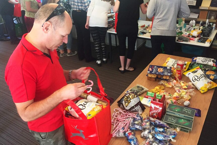 Volunteers pack Christmas hampers with sweets.