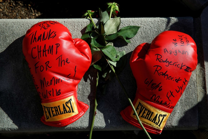 Boxing gloves with well wishes at a makeshift memorial.