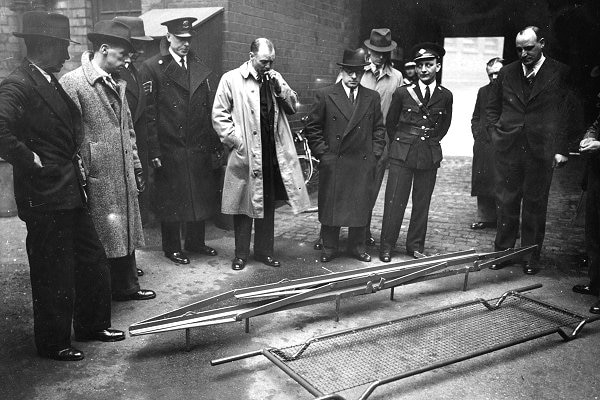 A group stands around a steelway stretcher used by Britain during World War Two.