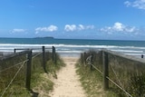 A sandy path leading to a beach.