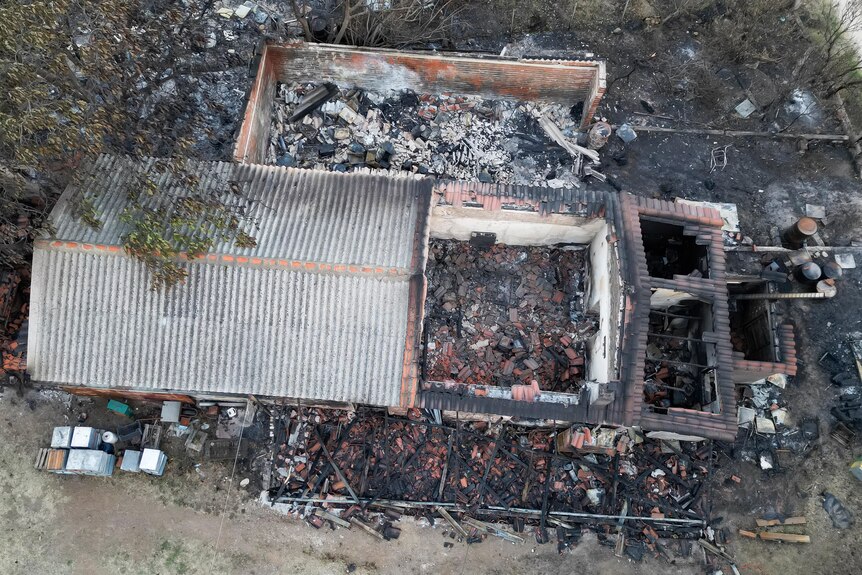 A view from above shows a house destoryed by fire.