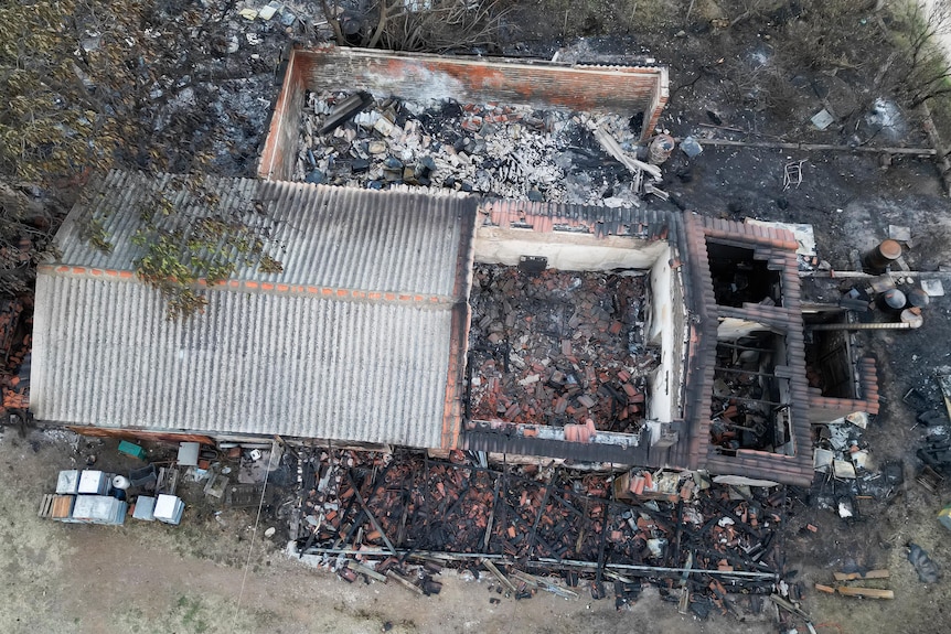 Una vista dall'alto mostra una casa distrutta da un incendio.