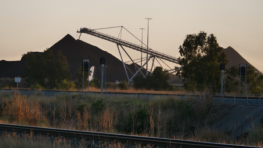 Railway line with coal mine operation in background