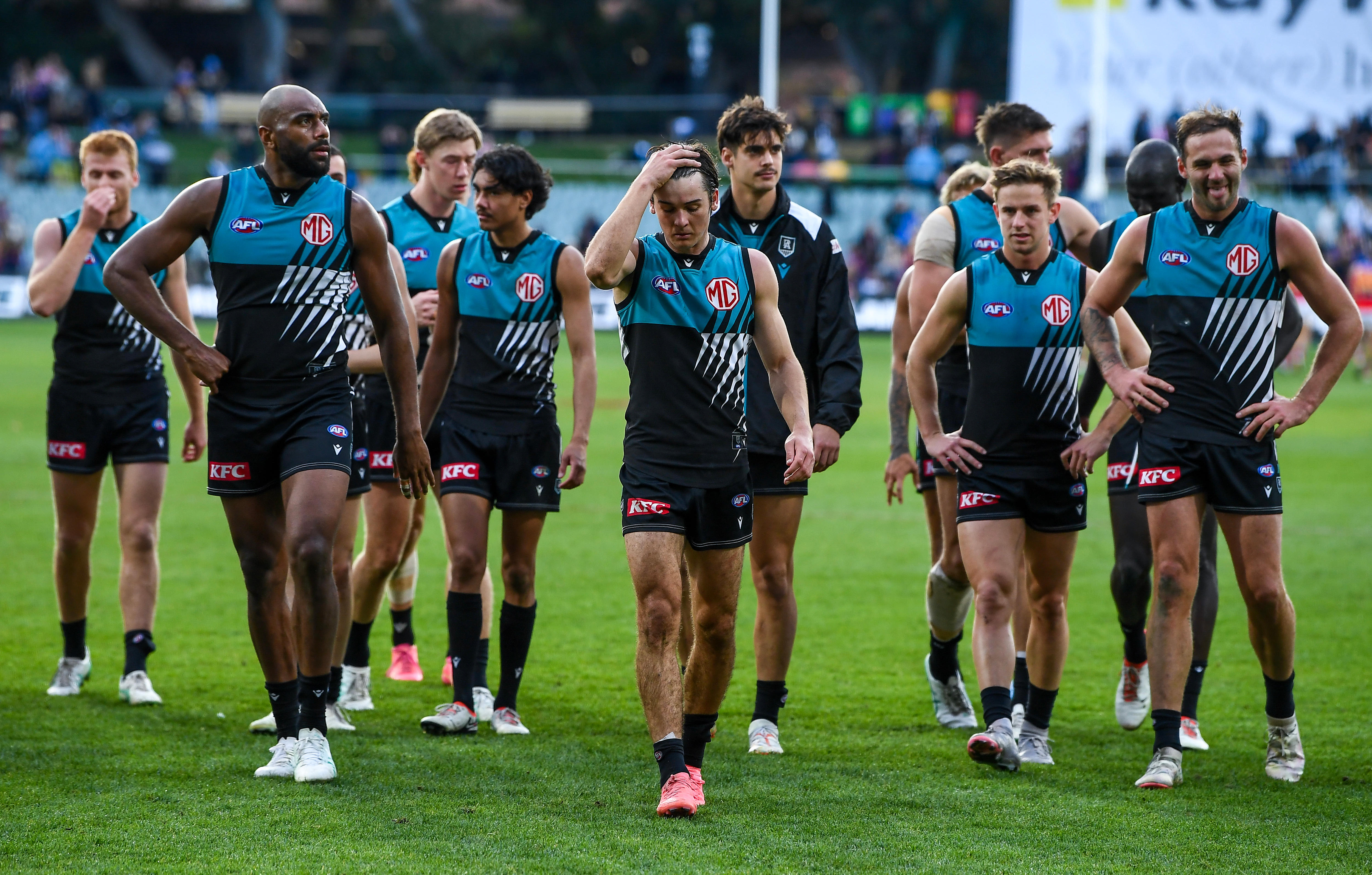 Port Adelaide players walk off the ground after losing to Brisbane
