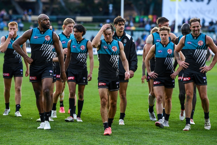 Port Adelaide players walk off the ground after losing to Brisbane