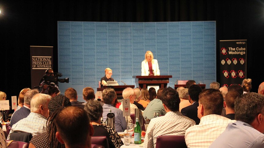 Room of people watch Bridget McKenzie speak on stage at National Press Club