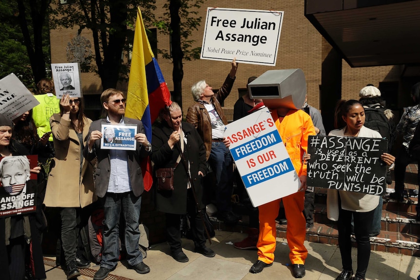Protesters holding signs saying 'Free Julian Assange' outside court as Assange is sentenced.