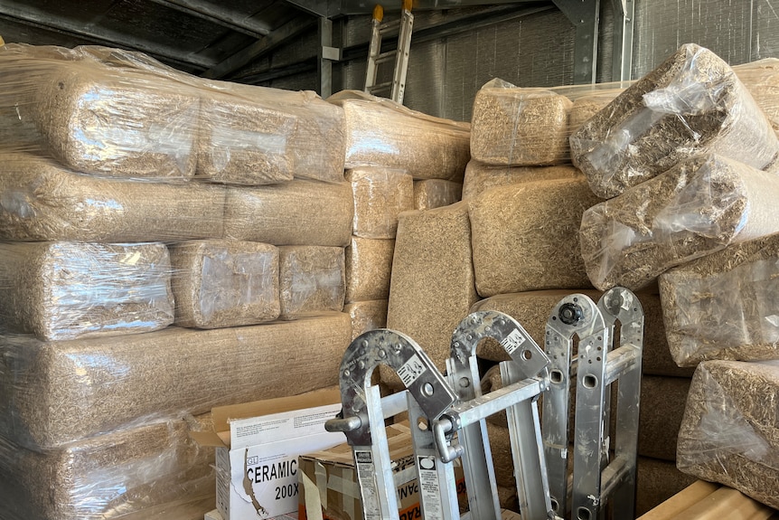 Large bags of hemp stacked up in a shed.