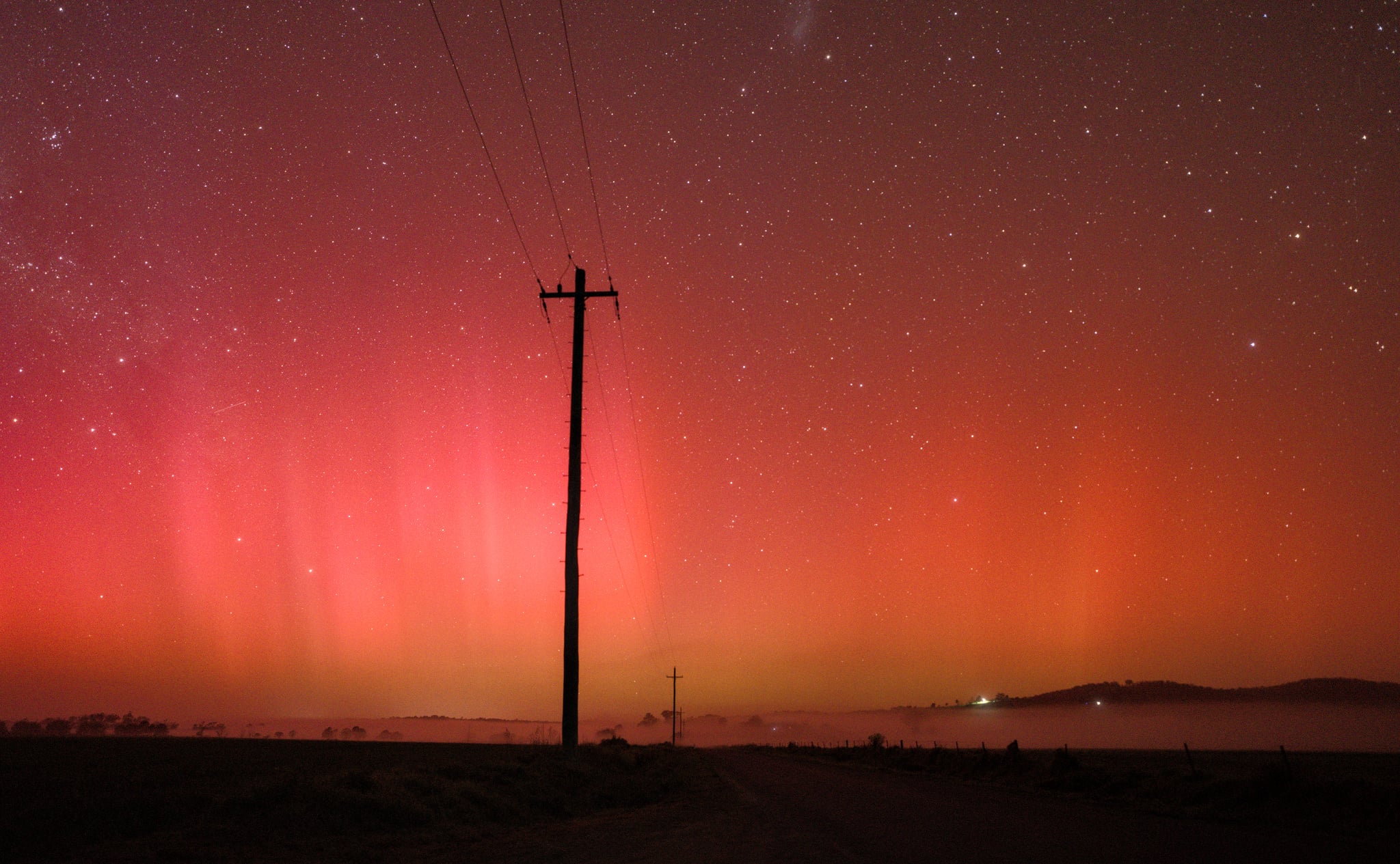 A pink and orange hue aurora in the night sky