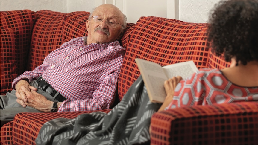 Frances Prince sitting with her father David on the couch and reading