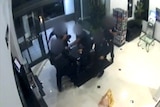 A still from a video of officers detaining Paul Gibbons after he begins filming them on his phone.